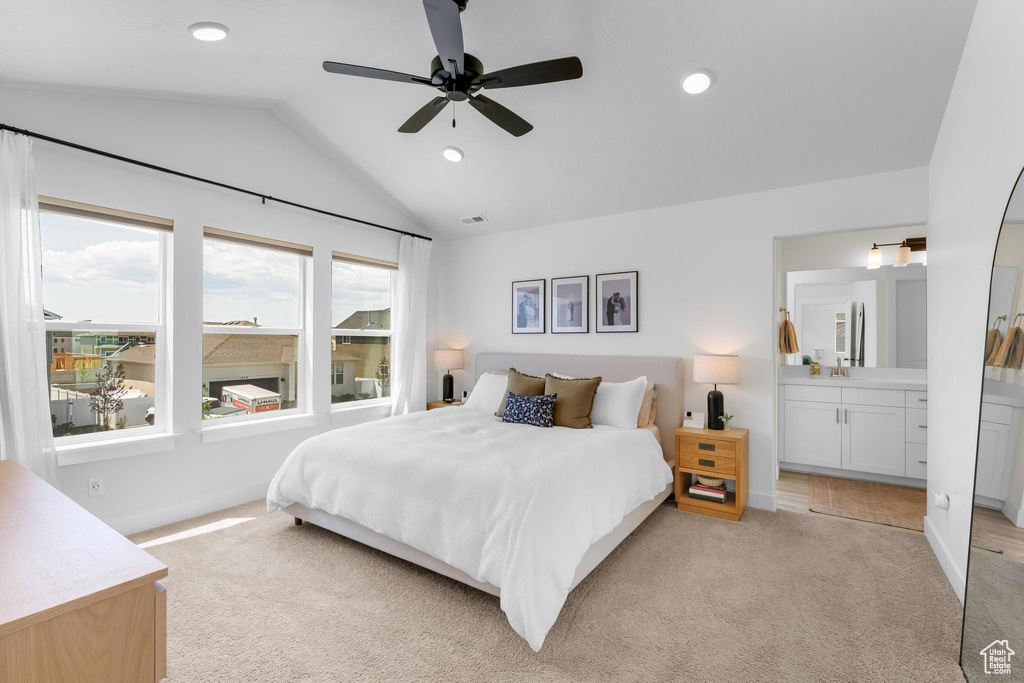 Bedroom featuring light colored carpet, lofted ceiling, ensuite bath, recessed lighting, and a ceiling fan