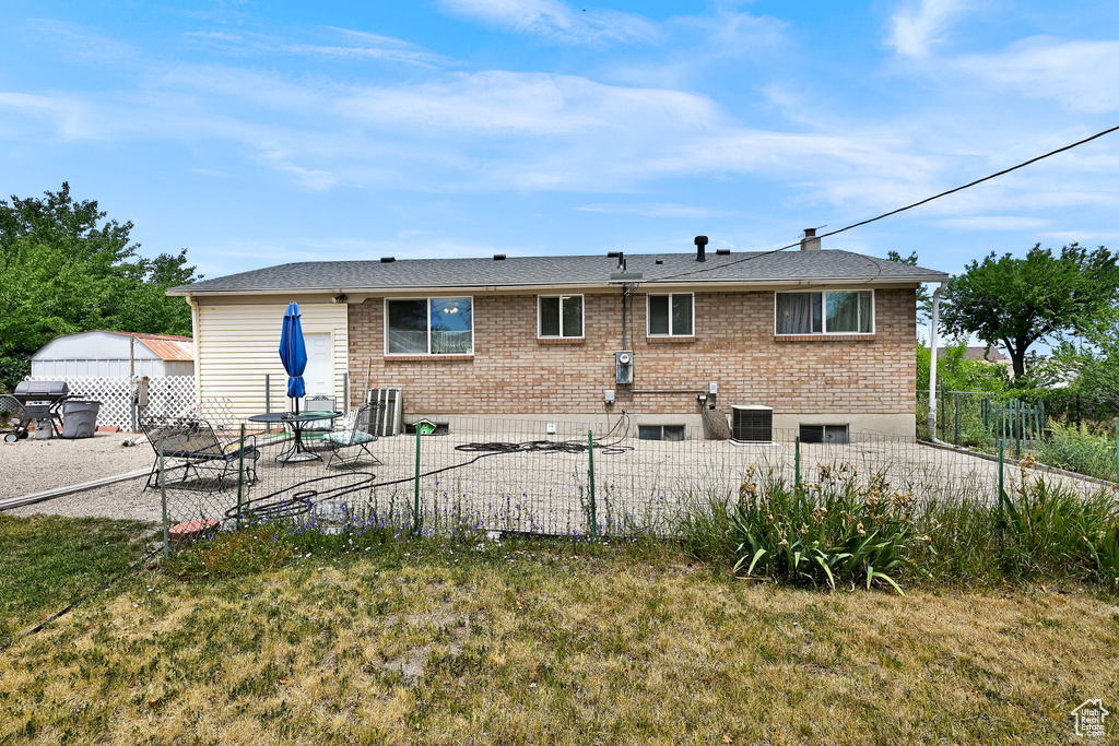 Back of house featuring brick siding and a patio