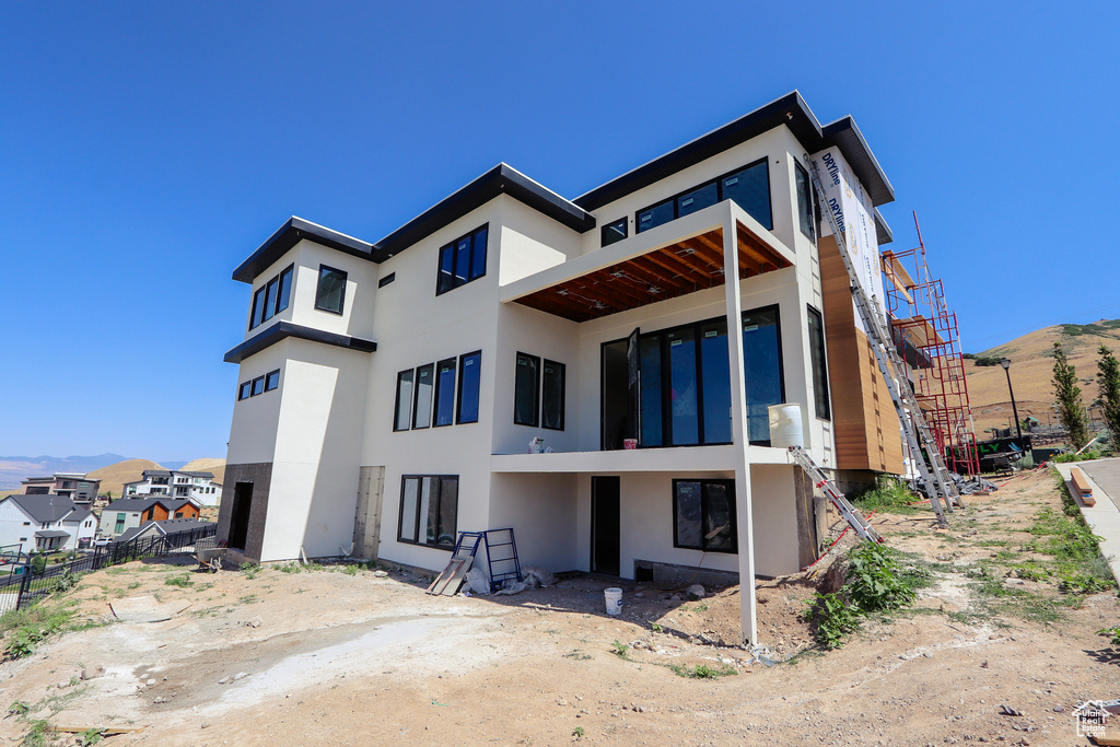 Rear view of house with stucco siding and a mountain view