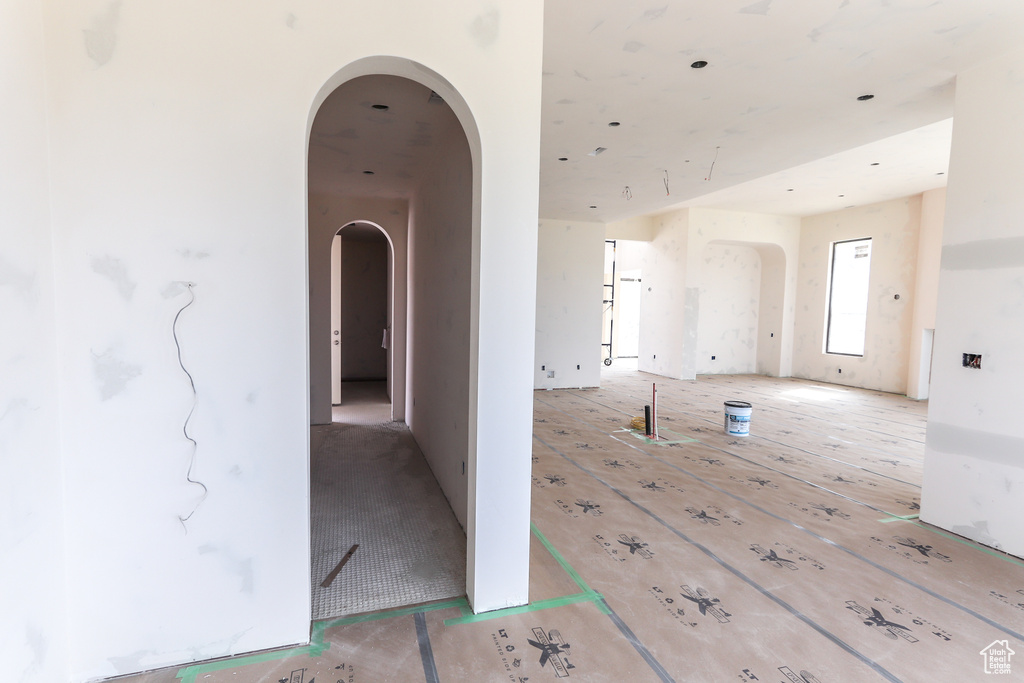 Corridor with arched walkways and wood finished floors