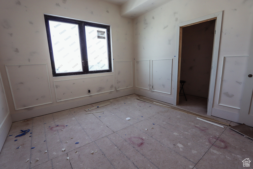 Unfurnished room with a decorative wall and a wainscoted wall