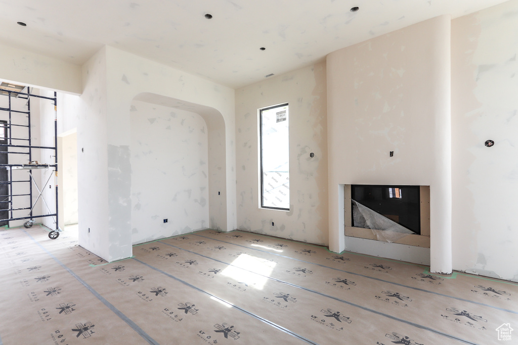 Unfurnished living room featuring arched walkways