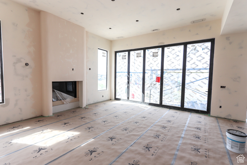 Unfurnished living room featuring a glass covered fireplace