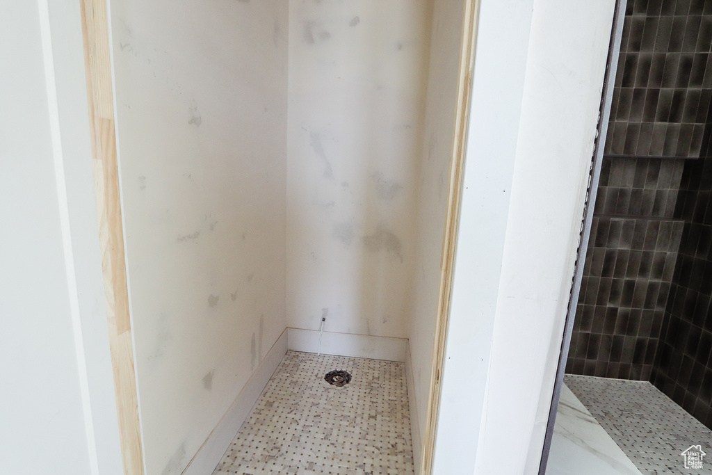 Bathroom with tile patterned floors and tiled shower