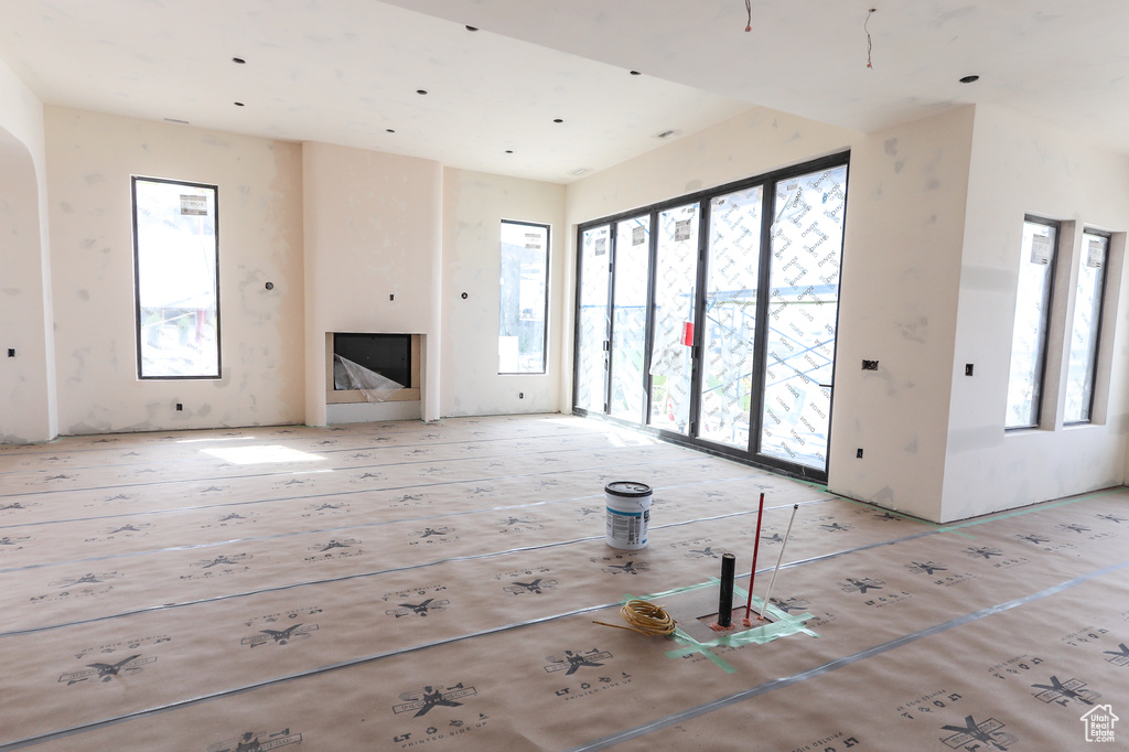 Unfurnished living room featuring arched walkways