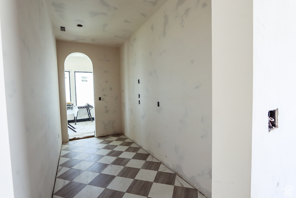 Corridor with arched walkways and light flooring