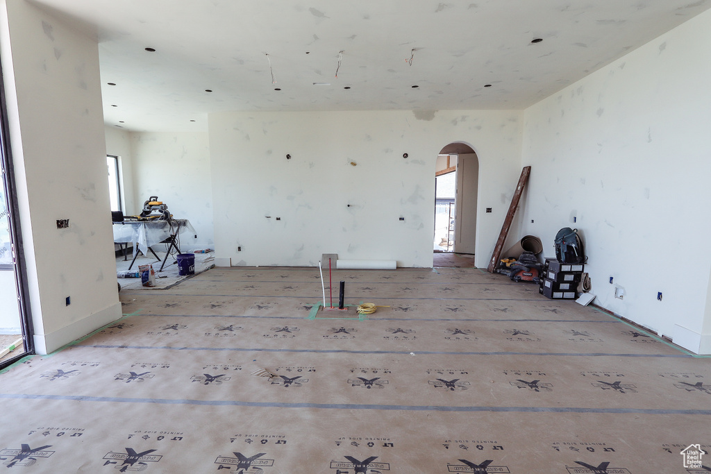 Unfurnished room featuring arched walkways