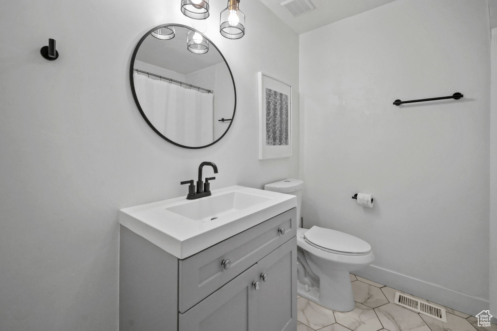 Full bath with vanity and marble look tile flooring