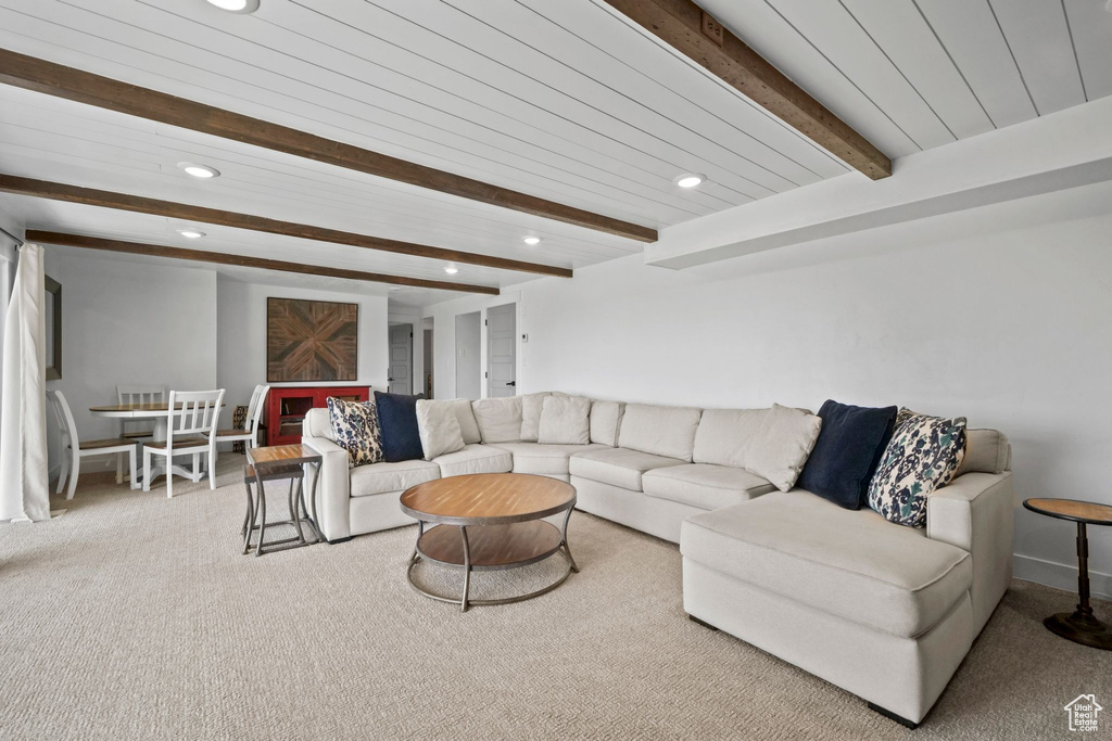 Living room featuring recessed lighting, beamed ceiling, and carpet flooring