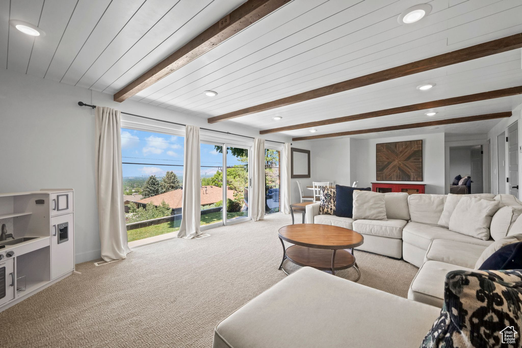 Carpeted living area featuring beam ceiling and recessed lighting