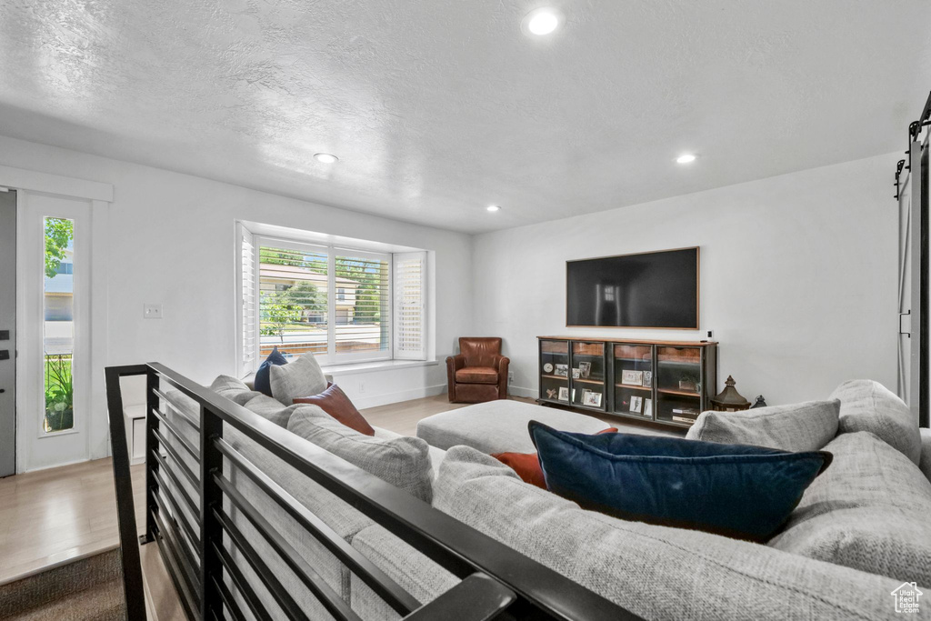 Living room with recessed lighting, a textured ceiling, and wood finished floors