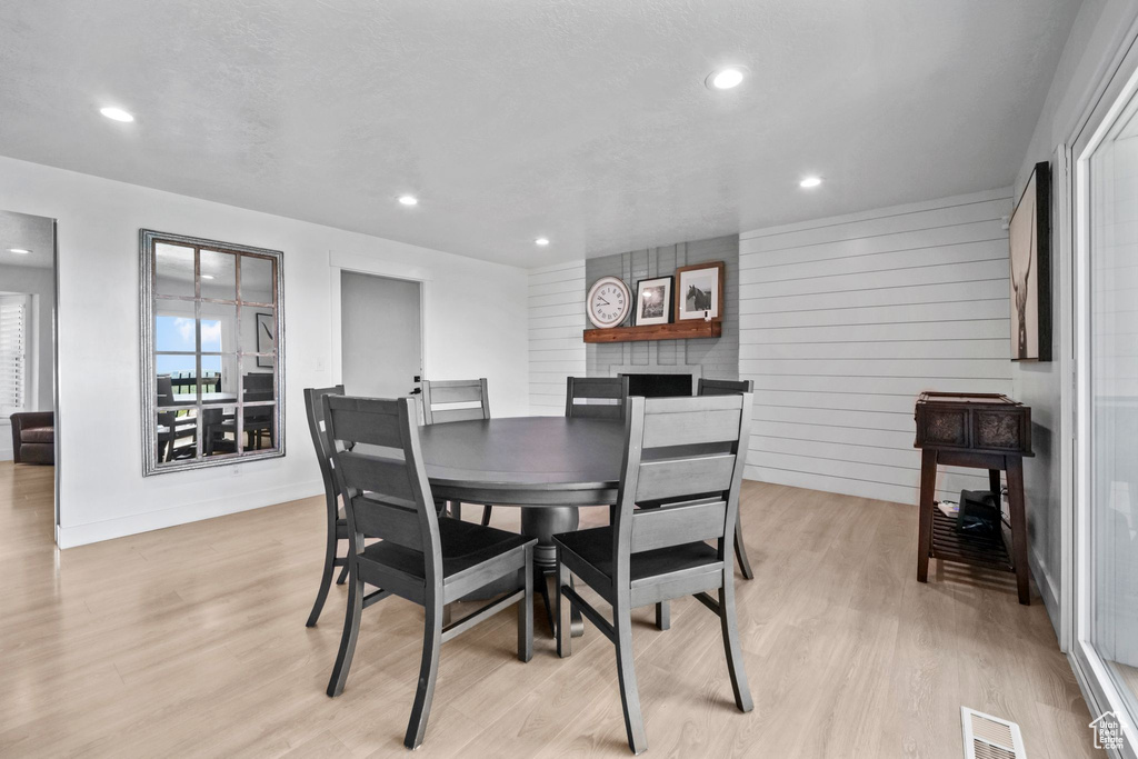 Dining area with light wood-style floors and recessed lighting