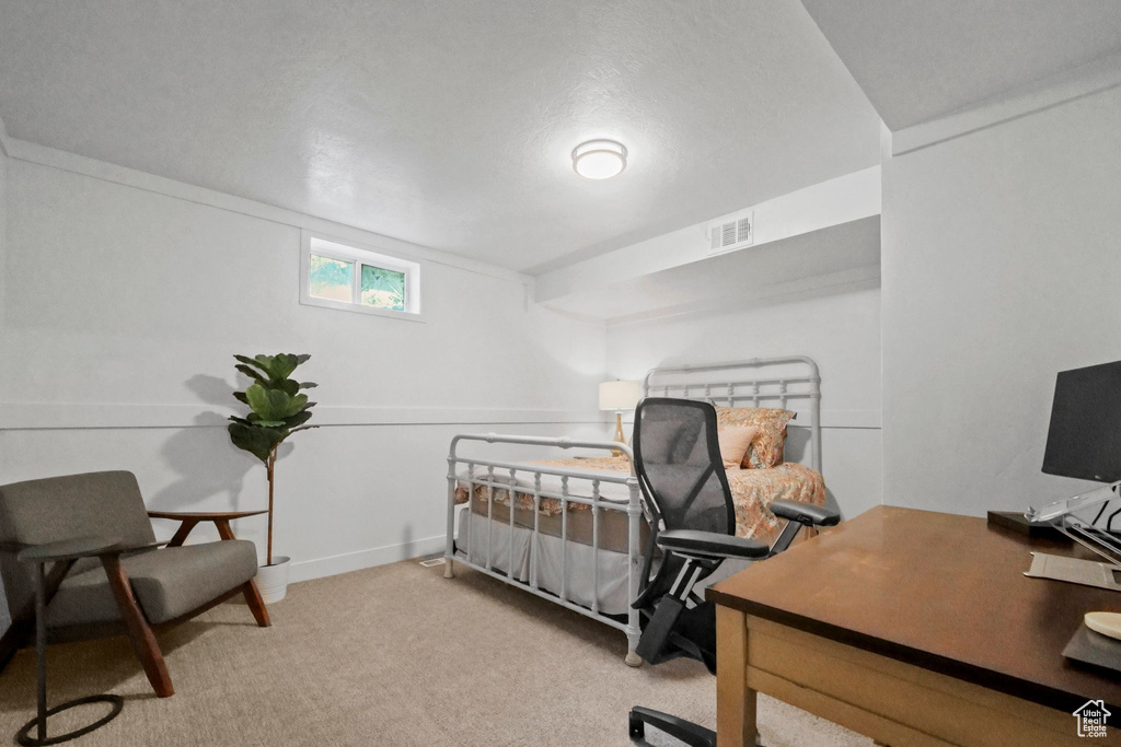 Bedroom with carpet flooring and a desk