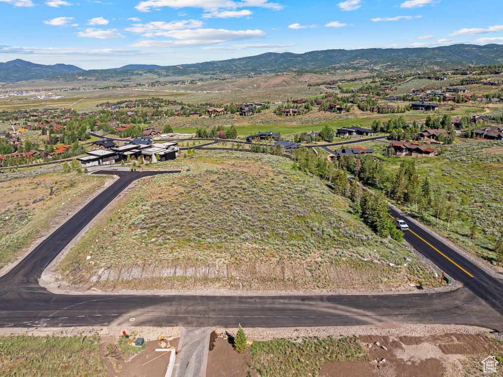 Aerial view of property and surrounding area featuring a mountainous background