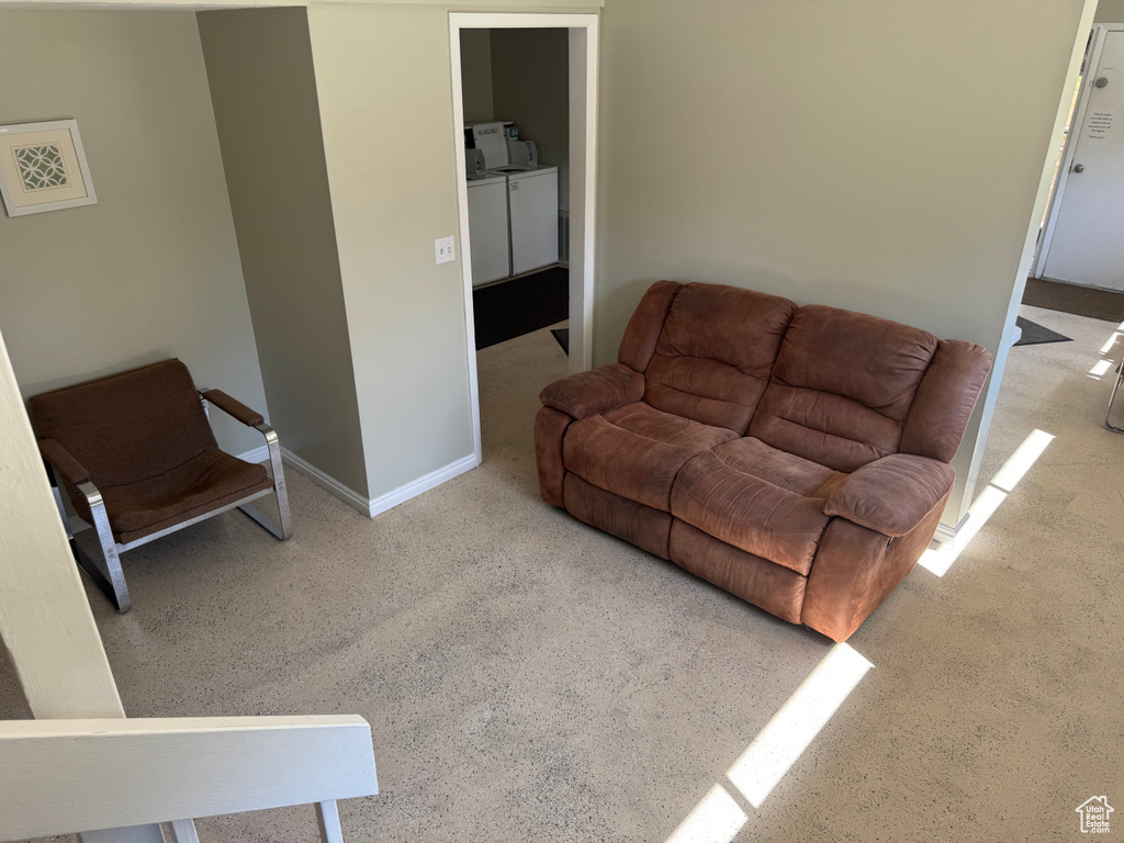 Living area with washing machine and clothes dryer and carpet floors