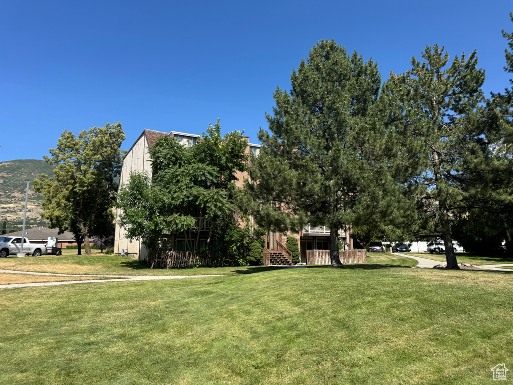 View of grassy yard featuring stairway