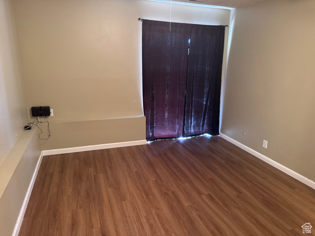 Unfurnished bedroom with wood finished floors and baseboards