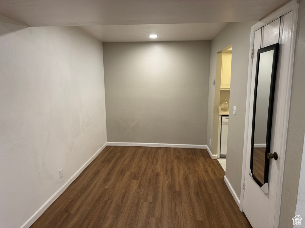 Empty room with dark wood-type flooring and recessed lighting