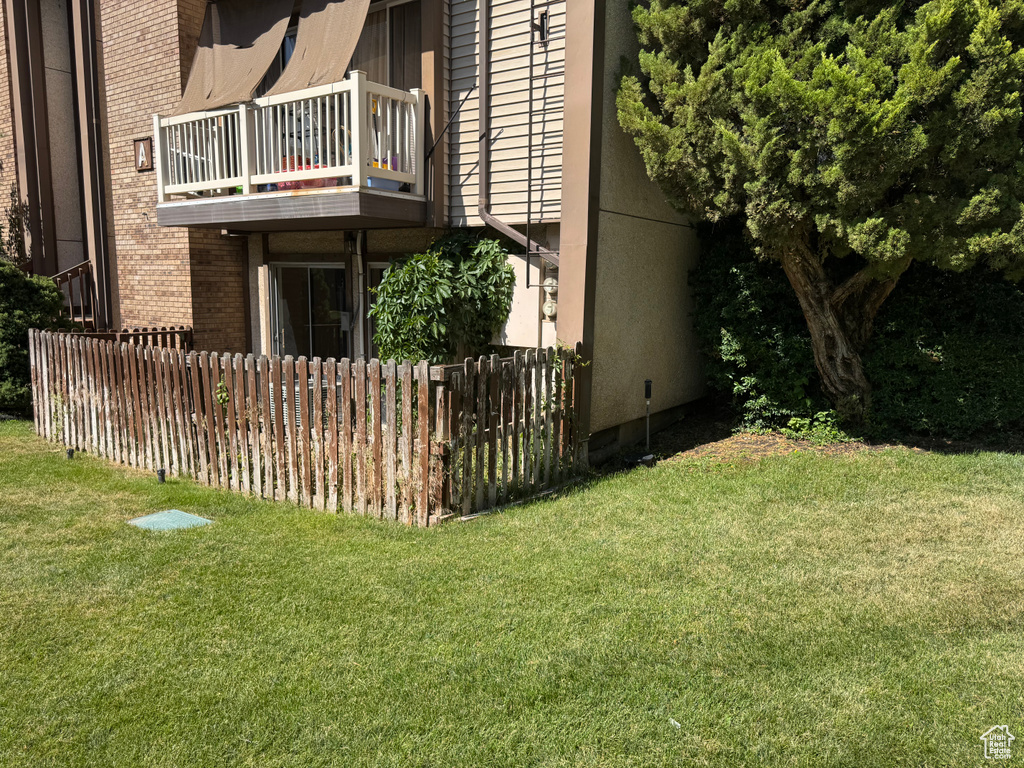 View of property exterior featuring a balcony and brick siding