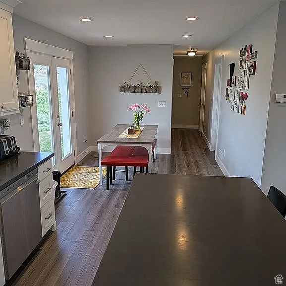 Dining space with dark wood finished floors, recessed lighting, and french doors