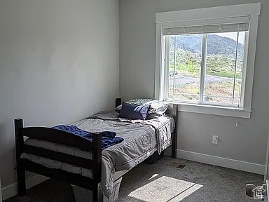 Bedroom featuring carpet flooring and baseboards