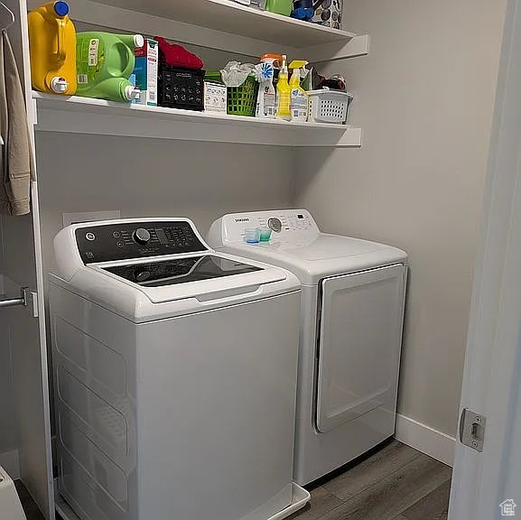 Laundry area featuring washing machine and clothes dryer and wood finished floors
