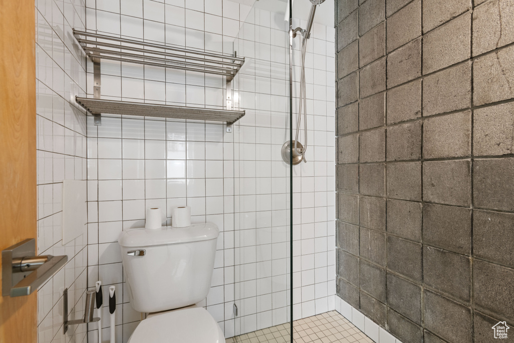 Bathroom featuring a stall shower and tile walls