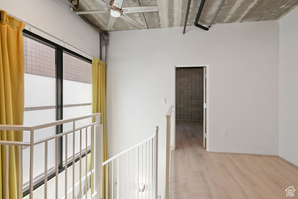 Hall featuring wood finished floors and an upstairs landing