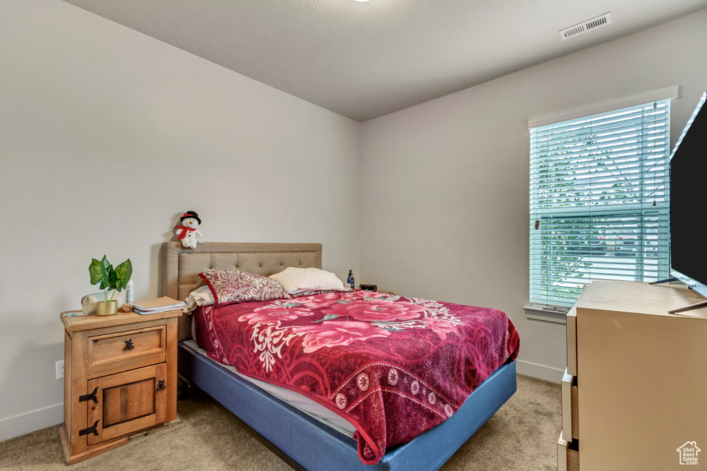 Bedroom featuring light colored carpet and baseboards