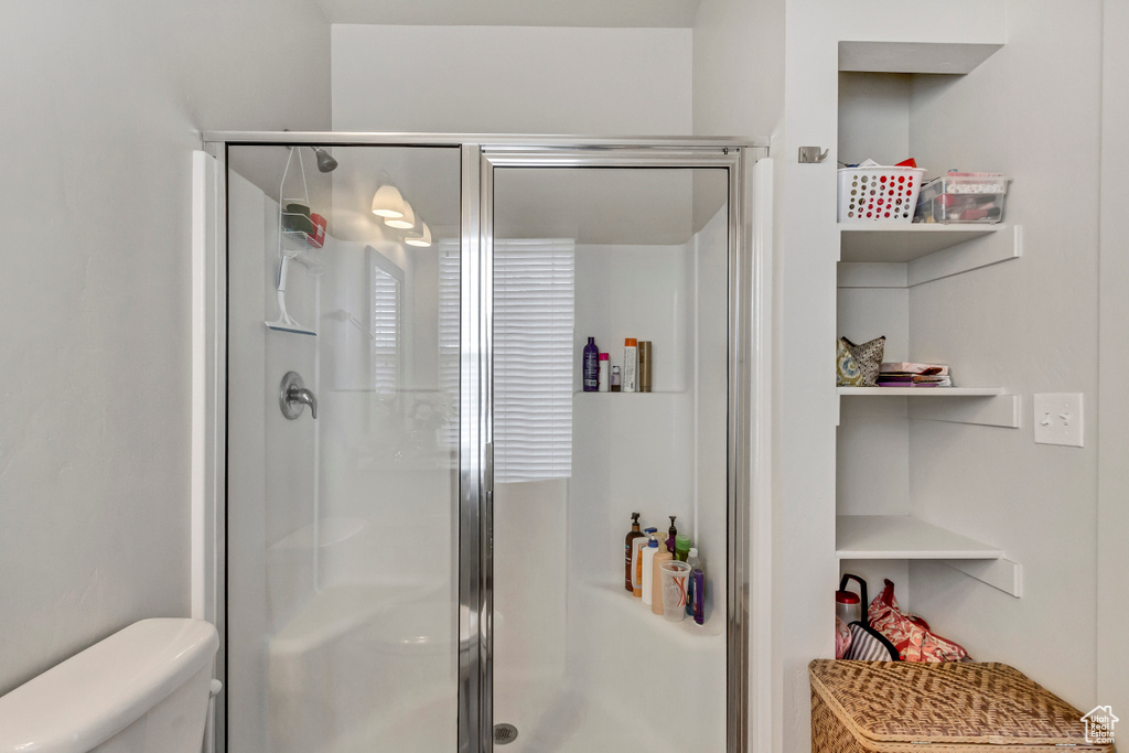 Full bath featuring toilet and a stall shower