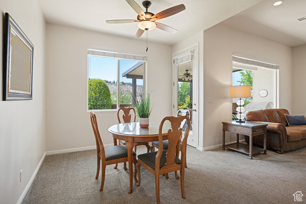 Dining room featuring carpet flooring, healthy amount of natural light, and ceiling fan