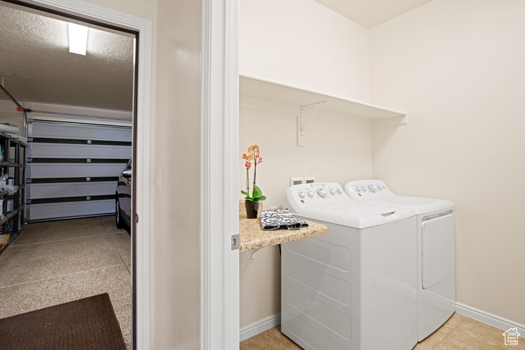 Laundry area with washer and dryer and a textured ceiling