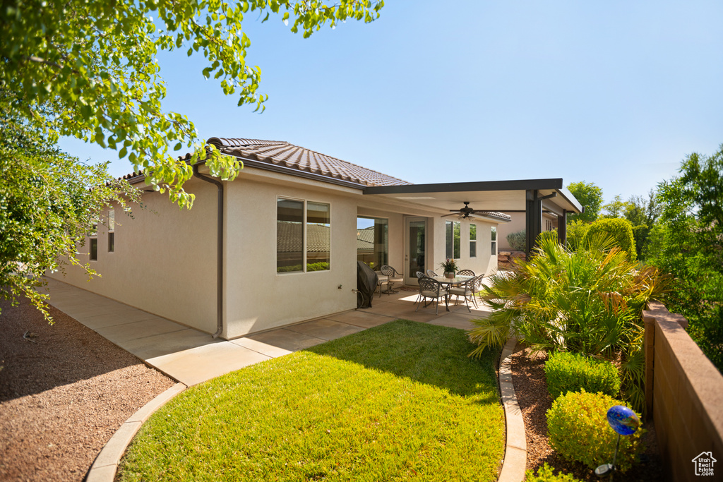 Back of house featuring a ceiling fan, a lawn, a patio, a tile roof, and stucco siding