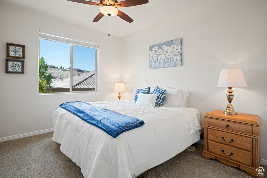 Carpeted bedroom with baseboards and ceiling fan