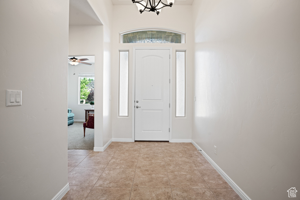 Foyer entrance with a chandelier and baseboards