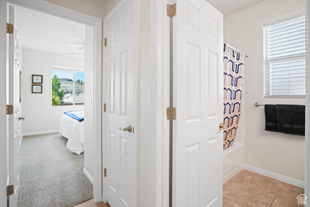 Ensuite bathroom featuring shower / bath combination with curtain and tile patterned flooring