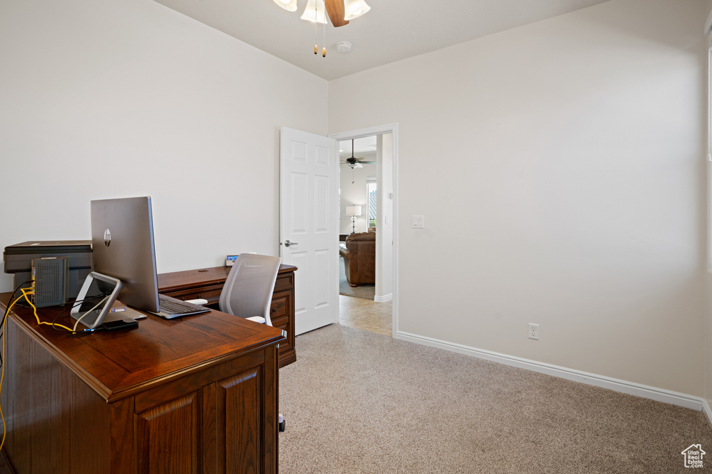 Office space featuring a ceiling fan and light carpet