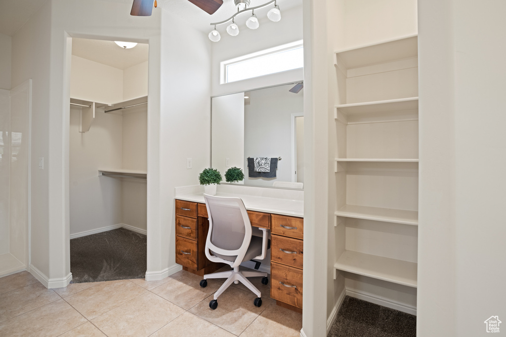 Office space featuring ceiling fan, light carpet, light tile patterned floors, built in features, and built in desk