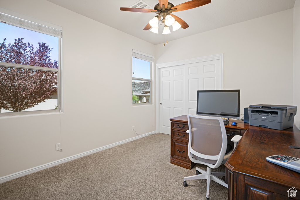 Office with a ceiling fan and light colored carpet