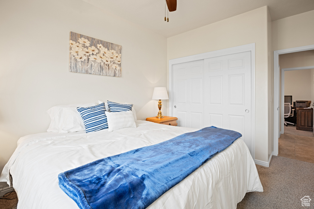 Carpeted bedroom with a closet and a ceiling fan