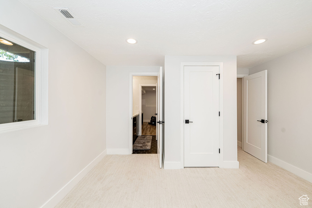 Unfurnished bedroom with recessed lighting and light colored carpet
