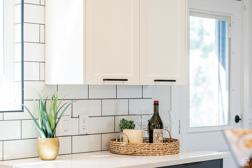 Kitchen view of white cabinets and backsplash