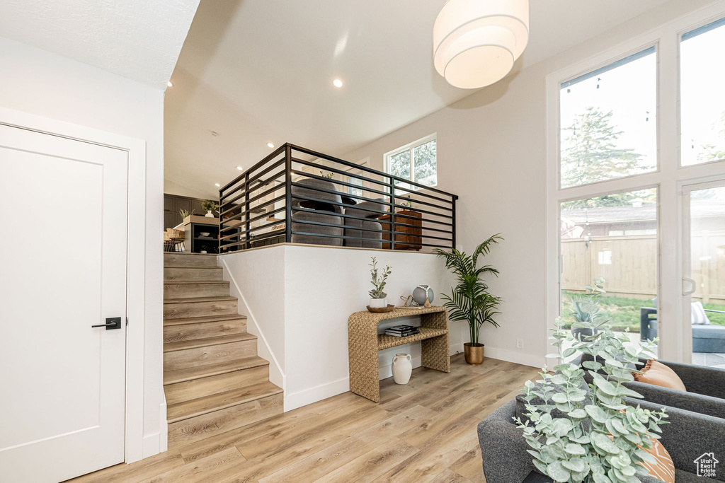 Stairway with wood finished floors and recessed lighting