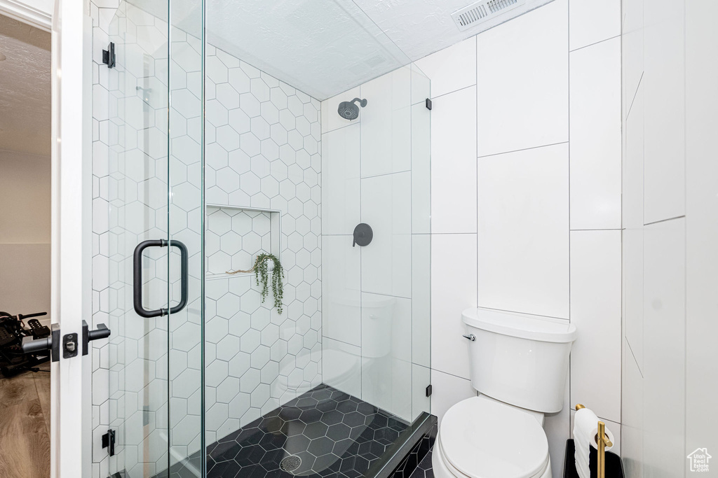 Bathroom with a shower stall and wood finished floors