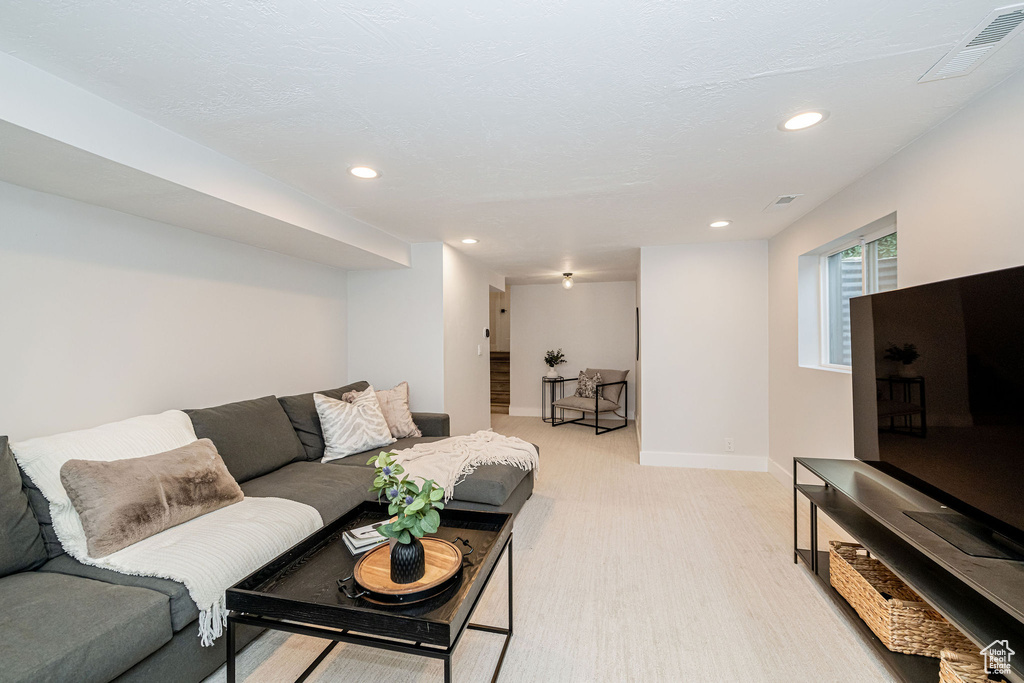 Living room with light colored carpet and recessed lighting