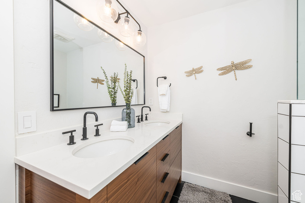 Bathroom featuring double vanity and baseboards
