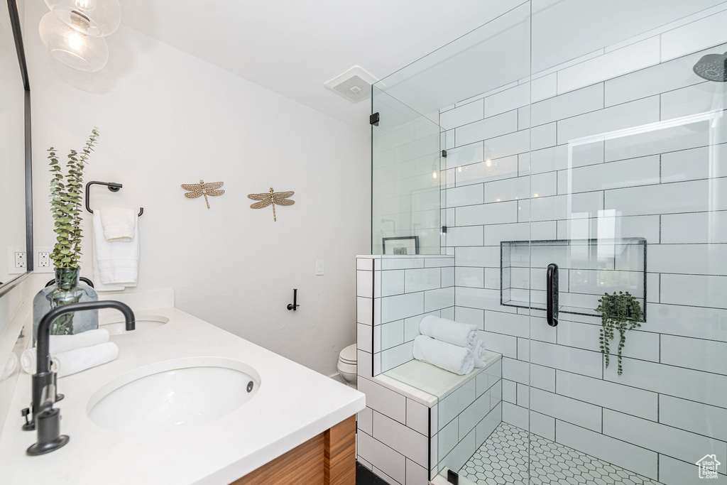 Full bathroom with double vanity and a shower stall