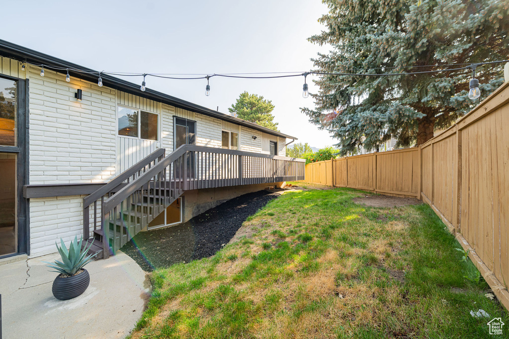 Fenced backyard featuring a deck and stairway