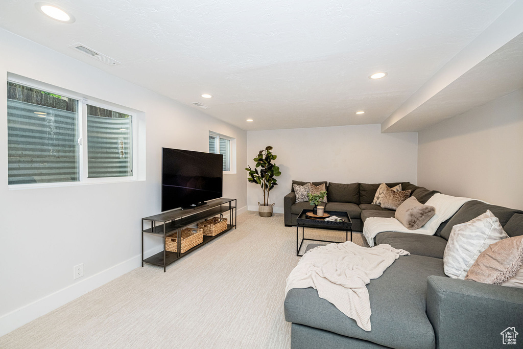 Living area with light carpet and recessed lighting