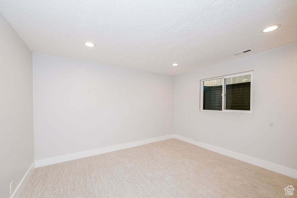 Carpeted spare room featuring recessed lighting and baseboards